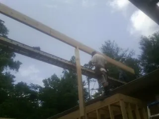 Carpenter setting a ridge beam over a new addition frame — Ice Dam Removal by Roofing Brothers in Igo