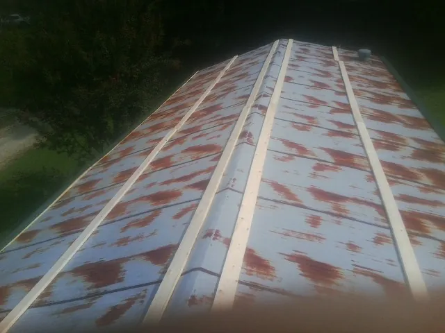 Rusted metal roof panels with new wood purlins before replacement — Storm Damage Roof Repair in Igo by Roofing Brothers