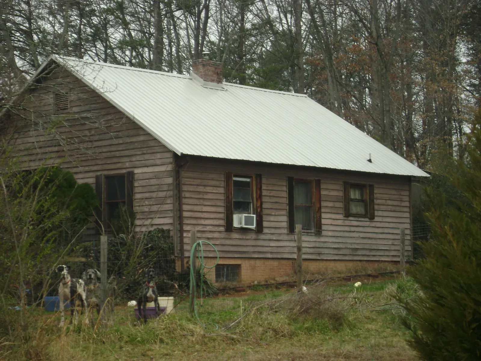 White metal roof on an old wood sided farmhouse, from a Metal Roof Installation job in Igo
